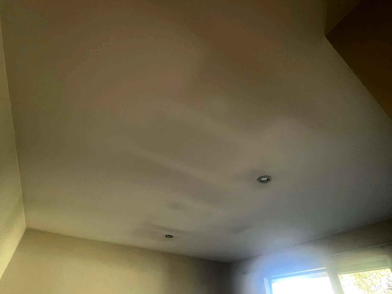 Bedroom ceiling showing thermal ghosting and grey discolouration tracing the framing before painting prep.