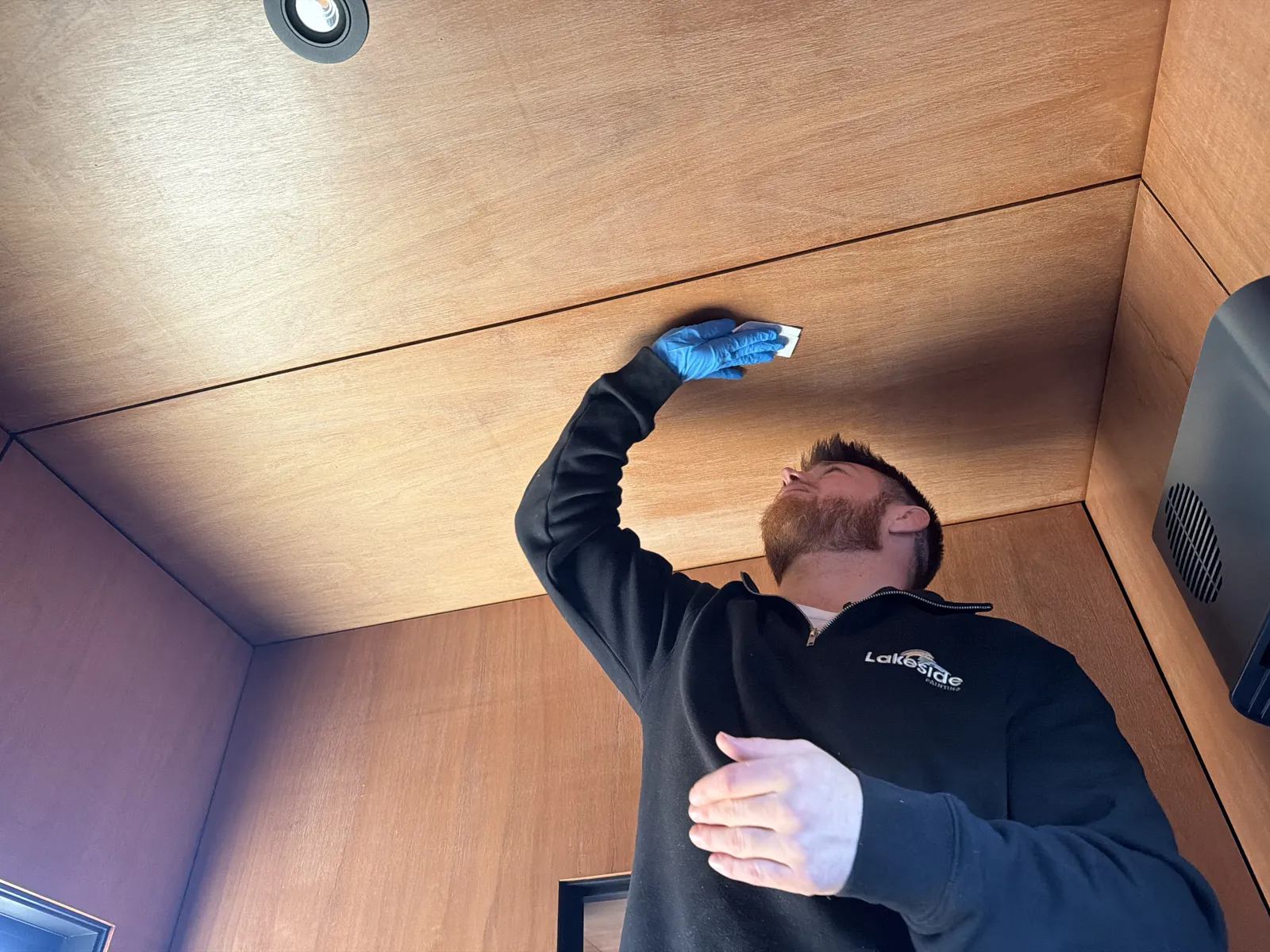 Sanding a small test patch on the timber ceiling to see how the old coating behaves