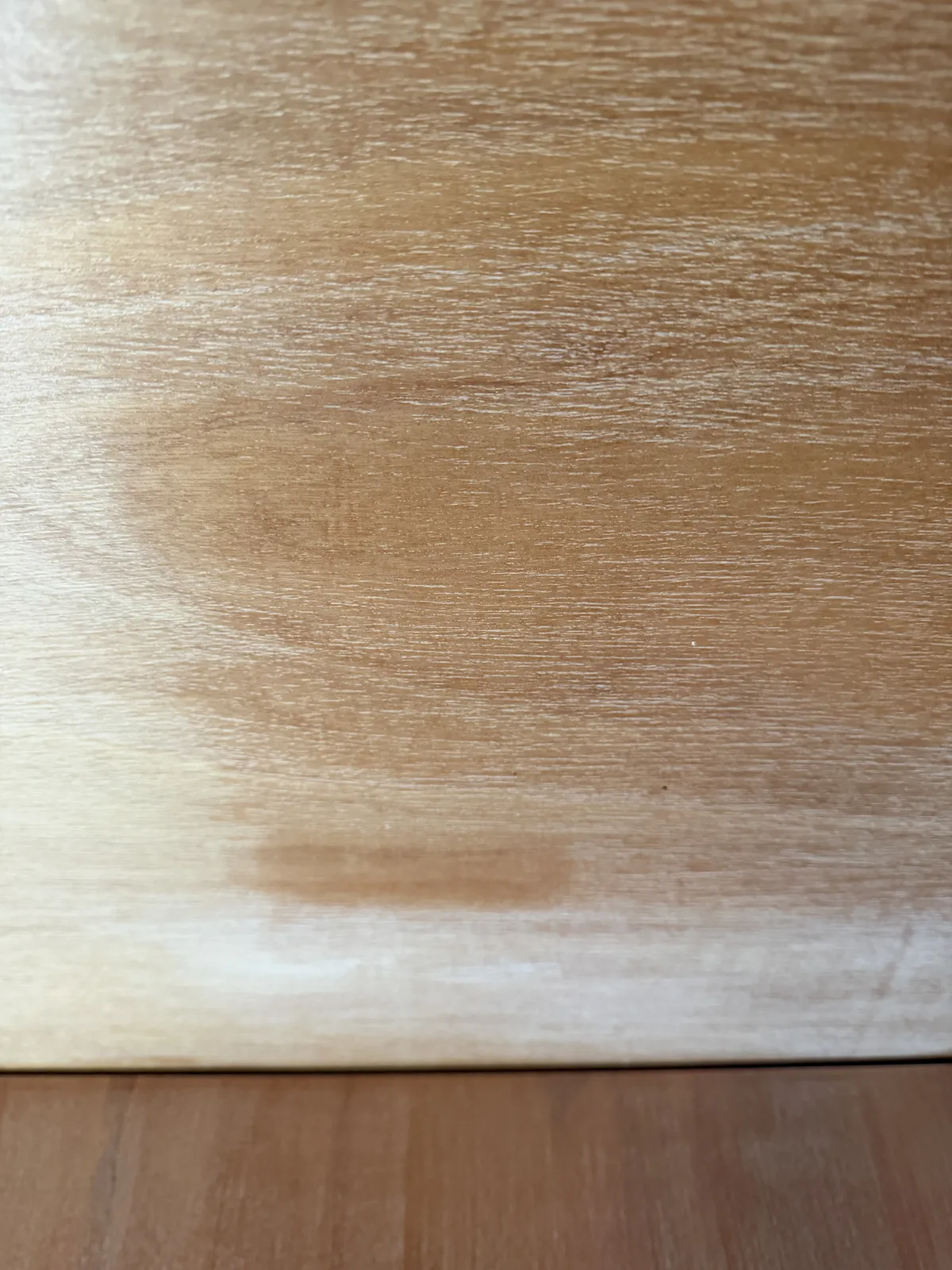 Worn clear coat on a timber panel, dull and dry with the finish wearing through